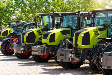Row of tractors displayed at outdoor farm machinery dealership © Barillo_Images