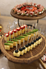 Beautiful, delicious buffet table with canapes, sausages, ham, cheese