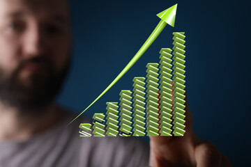 Stock photo of a man visualizing upward trending bar graph symbolizing growth, success, and...