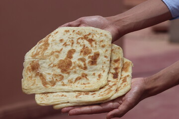 Hands holding Moroccan Msemmen or Msemen, Traditional moroccan flatbread