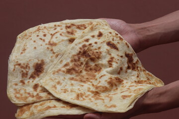 Hands holding Moroccan Msemmen or Msemen, Traditional moroccan flatbread