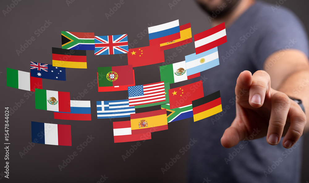 Poster Image of a person interacting with a digital display of various world flags, representing global communication and international relations.