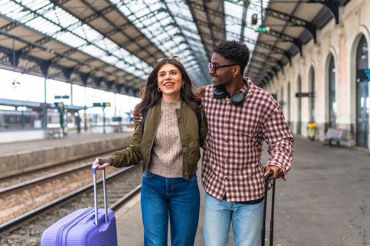 Happy tourists couple walking in train station