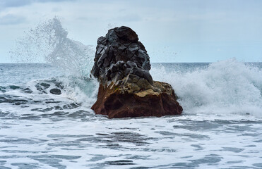 Waves crashing on volcanic rock