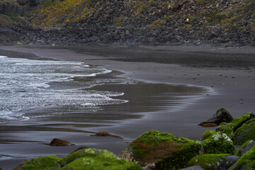 Black sand beach and shoreline rocks