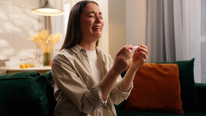 Anxious despair Caucasian pregnant girl female woman at home holding negative positive pregnancy...