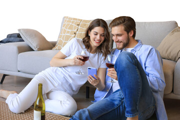 Happy couple sitting, relaxing on floor in living room, drinking red wine. Smiling young husband and wife rest at home enjoy romantic date on family weekend together on a transparent background
