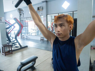 Asian men use gym equipment to do tricep, chest, arm exercises, focusing on building strength and...