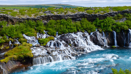 Serene beauty of Barnafoss and Hraunfossar waterfalls in Icelands lush landscape