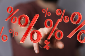 Hand interacting with 3D percentage symbols.  Ideal for finance, discounts, and sales.
