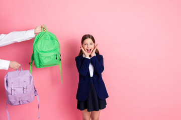 Excited schoolgirl with bright backpacks on pink background highlighting back to school time and...