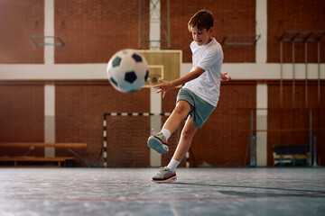 Elementary student playing soccer during physical education class at school. © Drazen