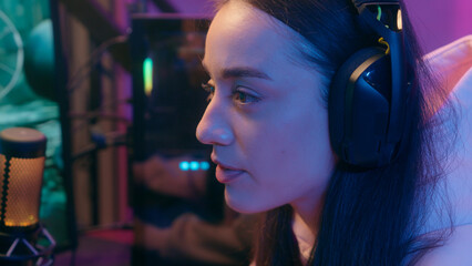Caucasian concentrated female gamer girl woman typing keyboard looking at computer monitor playing...