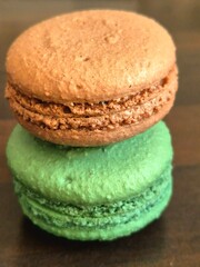Two delicious French macarons are delicately stacked, showcasing their signature crisp meringue shells and visible creamy filling.