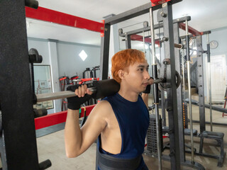 Asian Indonesian man plays dumbbell exercise to train arm endurance to strengthen and tighten...