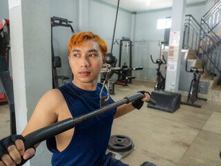 Asian men use gym equipment to do tricep, chest, arm exercises, focusing on building strength and...