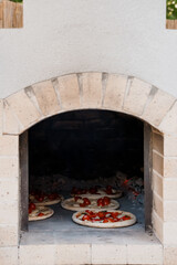 Rustic Stone Wood-Fired Pizza Oven with Margheritas Cooking Inside, Outdoor Kitchen, Warm Lighting,...