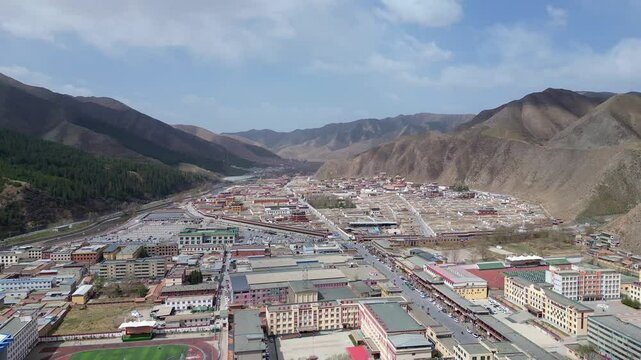 Xiahe, China: Aerial forward footage of the Tibetan Buddhism Labrang Monastery  in the Xiahe town in the Amdo region of Gansu on the Tibetan plateau. Shot with a tilt down motion
