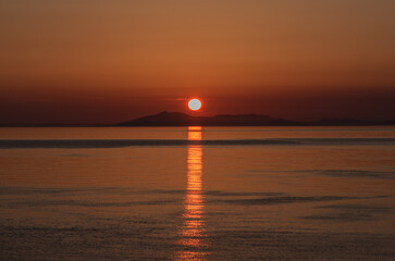 島に落ちる夕日と海に反射する太陽の光
