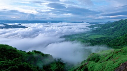 Cloud-covered mountains with green valley below, misty atmosphere