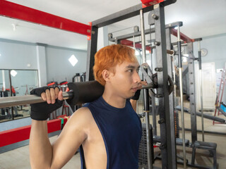 Asian Indonesian man plays dumbbell exercise to train arm endurance to strengthen and tighten...