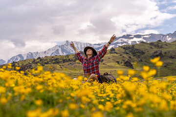 Mountains Flowers Woman: Hiker celebrates among blossoms, Caucasus, sunny day, appreciating nature.