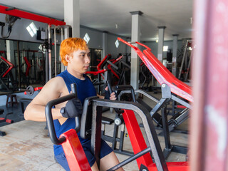 Asian men use gym equipment to do tricep, chest, arm exercises, focusing on building strength and...