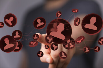 Hand interacting with a network of connected people, symbolizing social media, networking, and online communities.