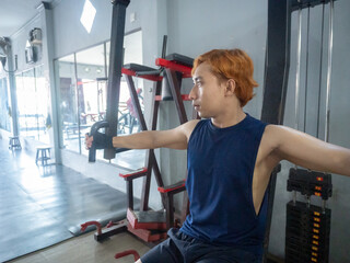 Asian men use gym equipment to do tricep, chest, arm exercises, focusing on building strength and...