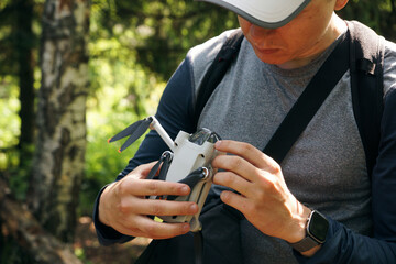 Man pilot checking quadcopter drone propeller blades before aerial flight