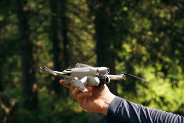 A man holds a drone in his hand. A man is about to launch a quadrocopter