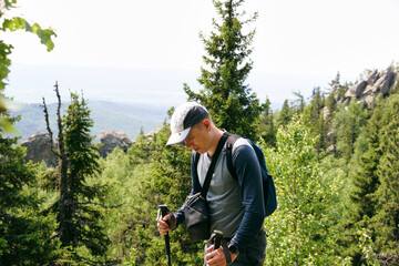 A young hiker with trekking poles in the forest.