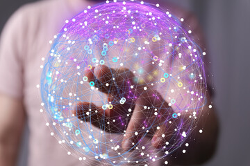 Abstract image of a hand interacting with a digital sphere, representing global networking and...