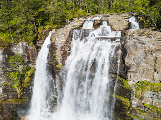 Fototapeta premium An aerial view of the upper part of the famous Svandalsfossen waterfall in Norway: a turbulent stream of water forces its way through the rocky riverbed before the main drop.