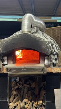 Traditional wood-fired brick pizza oven in use.