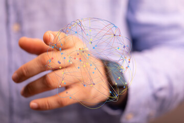 Abstract image of a network connection visualized as colorful lines and nodes, held in a person's...