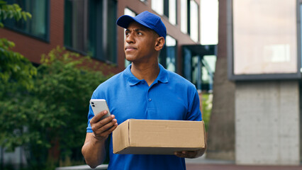 Pensive African American courier man delivery guy male postman small business searching location...