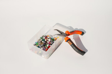 Craft beads and pliers on table for jewelry making