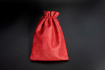 Elegant red fabric gift bag on black background with drawstring closure