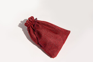 Elegant red burlap drawstring gift bag against a plain background