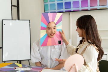 Stylist consulting client with color palettes in creative studio
