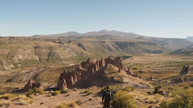 Man walking on a dramatic rock formations landscape known as of Los Bolillos, located at North of Neuquen province, Argentina