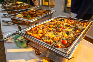Vegetable lasagna in a metal dish at a buffet 