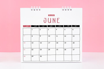 Desk calendar for June 2026 on a pink color background with copy space.