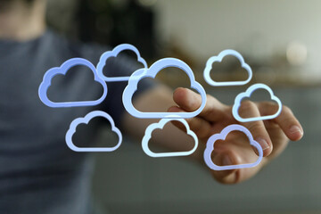 Image depicts hand interacting with cloud icons, symbolizing secure cloud computing, data storage,...