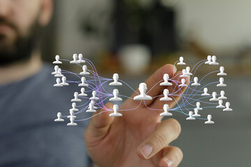 Hand interacting with a digital network of people, symbolizing connections and communication.