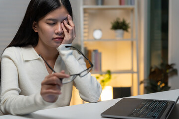 Eye problems, Asian women with tired and irritated eyes, eye rubbing, dry, eye pain after work, migraine, headache, blurred vision, photophobia, working in the dark, blue light from computer screens