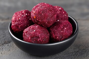 Deliciously crafted vibrant beetroot energy balls arranged in a sleek black bowl showcasing a healthy snack option packed with nutrient-rich ingredients for a wellness-focused lifestyle