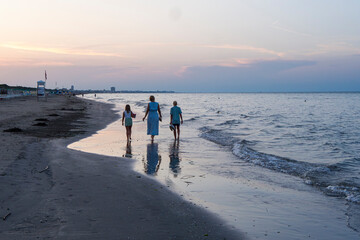 Italy, Emilia Romagna, Cesenatico, family on the beach