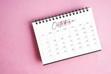 Top view of October 2026 desk calendar on pink pastel background.